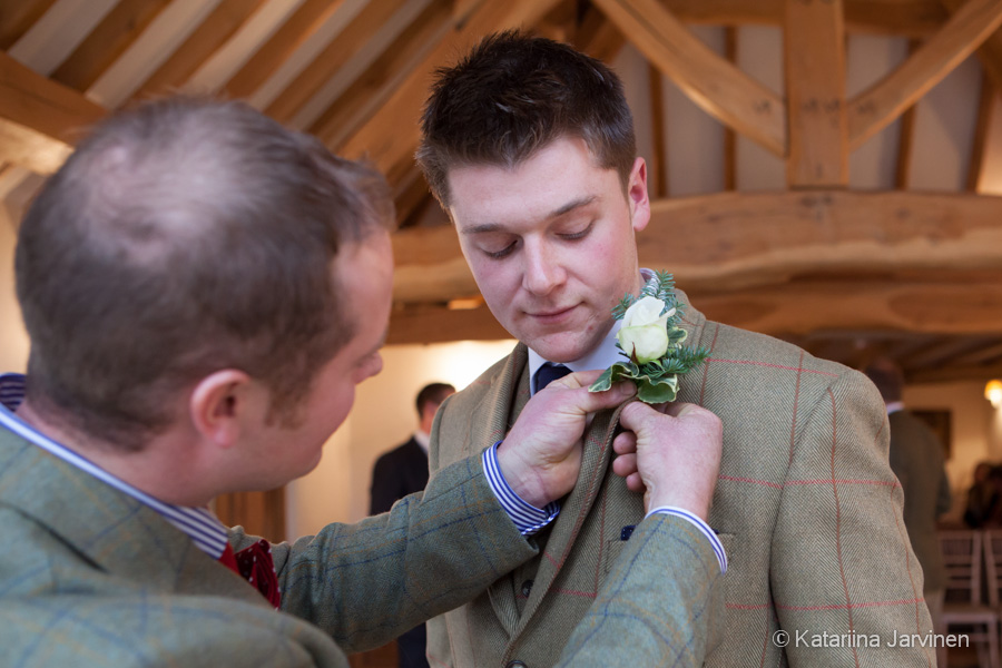Best Man helping groom with rose button hole